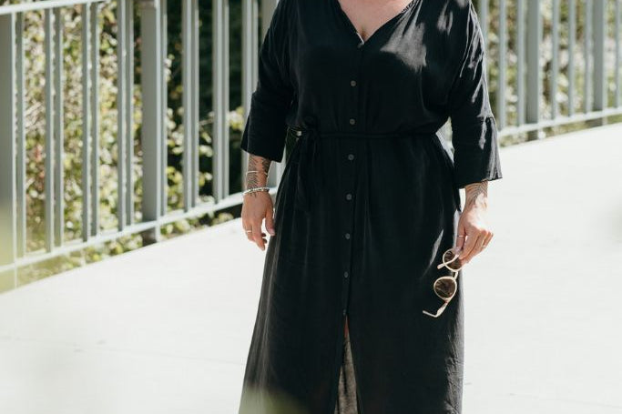 Die Frau auf dem Foto trägt das Kleid Kim, welches vorne zugeknöpft werden kann