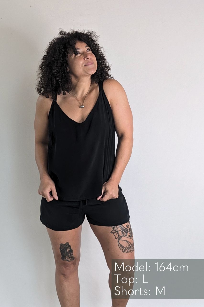 le modèle pose dans un top Kat et un short assorti Kat en regardant le plafond