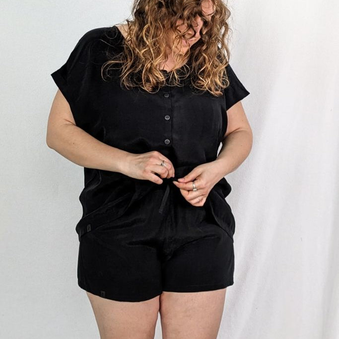 Le modèle pose dans le haut boutonné Noe avec le short assorti Kat