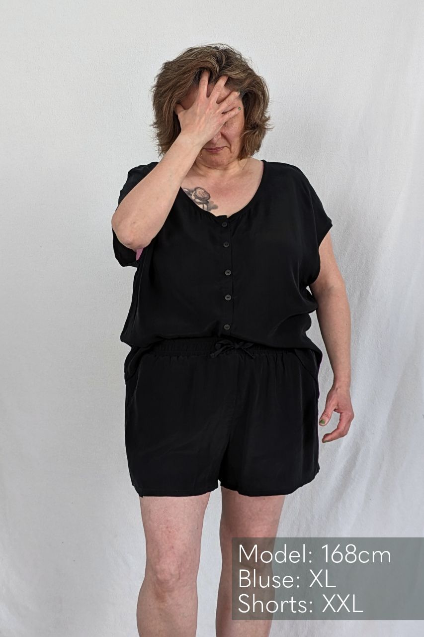 La femme couvre son visage et montre le haut Noe en noir et le pantalon Kat en court