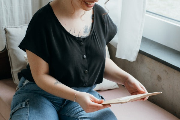 la femme regarde la commande en portant le petit chemisier boutonné de Noe