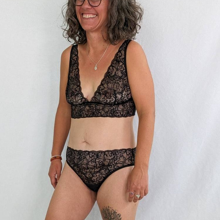 Femme en soutien-gorge et Slip en dentelle sourit joyeusement.