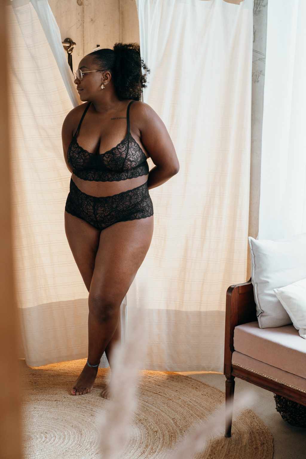 Un mannequin sort de la cabine d'essayage en lingerie noire.