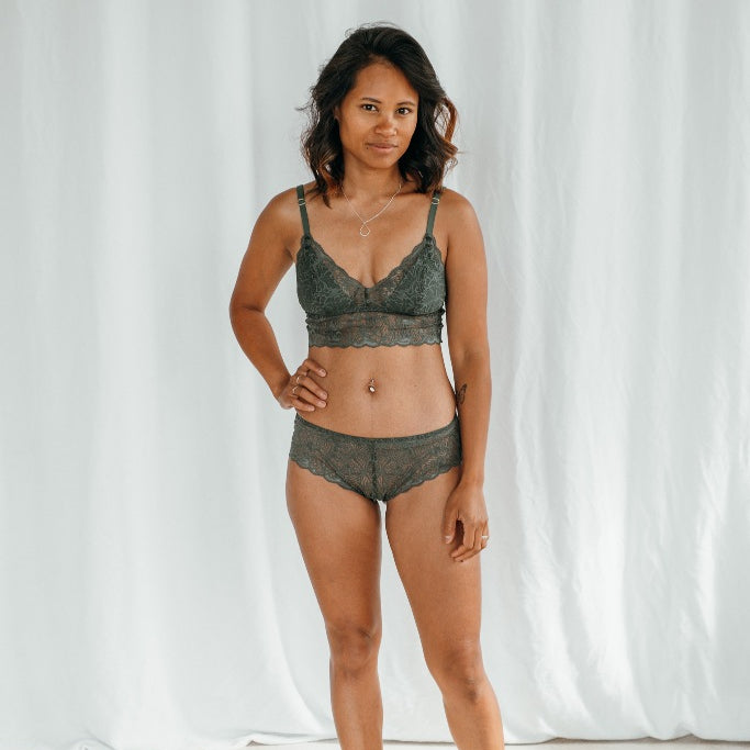 Le modèle porte Vivi Bralette avec des coussinets amovibles et Slip assorti en vert foncé dentelle.