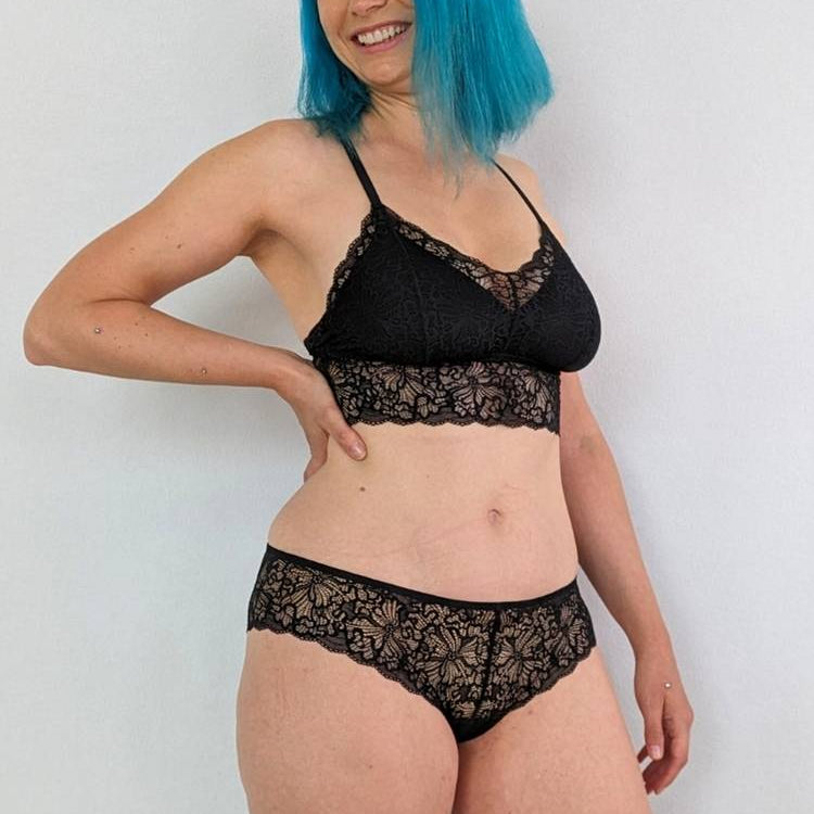 Le modèle aux cheveux bleus porte Bralette avec des coussinets en noir.