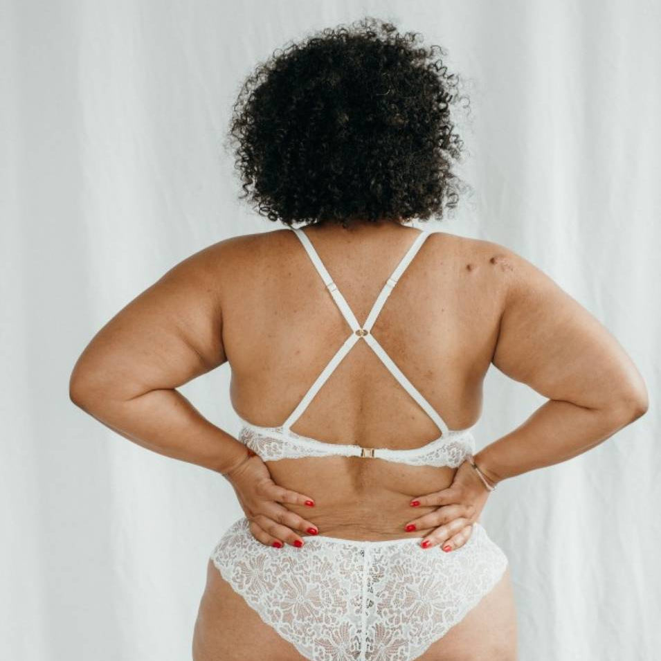 Vue de dos de Vivi en blanc en dentelle à motifs romantiques .