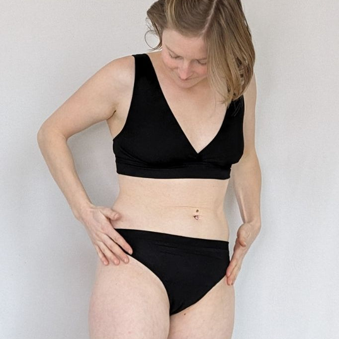 String La modella in piedi indossa un reggiseno e una maglia