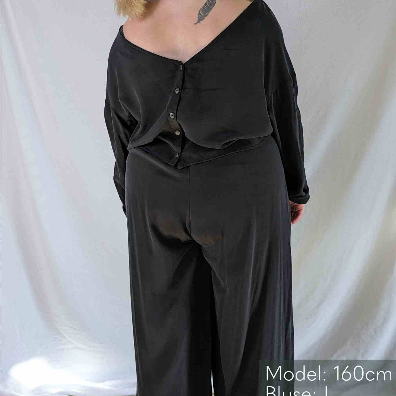 Une femme en chemisier noir et Pants lève les yeux.