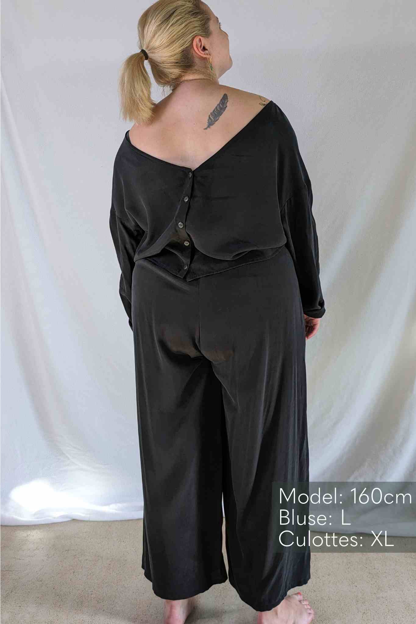 Une femme en chemisier noir et Pants lève les yeux.