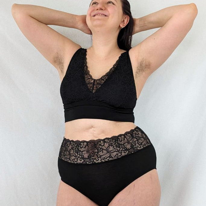 Sur la photo, on voit de beaux sous-vêtements en noir, avec un Slip qui montre une taille haute en dentelle