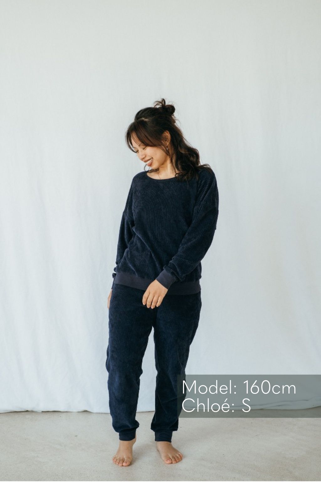 Model trägt Pyjama in Dunkelblauem Cord mit weichen Bündchen