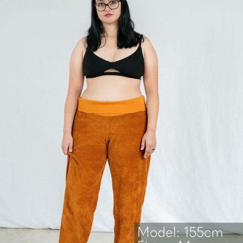 Model in Bralette präsentiert die gerade Geschnittene Hose in Ocker