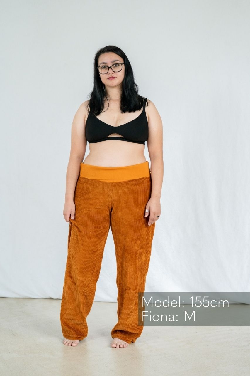 Model in Bralette präsentiert die gerade Geschnittene Hose in Ocker