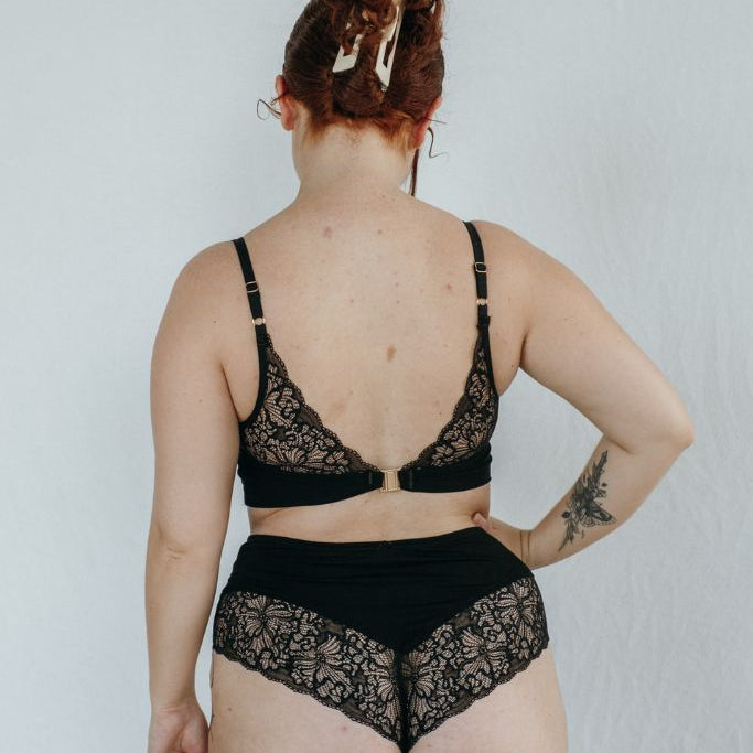 die Frau trägt schöne Dessous in schwarz mit einem hohen Slip aus Jersey und Spitze