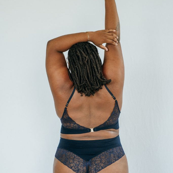 die Frau hält die Hände gen Himmel und zeigt die Rückenansicht von der wunderschönen Unterwäsche Sophie