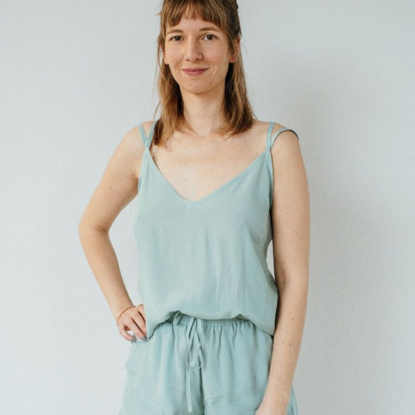 La femme fait face à l'appareil photo et pose en Kat haut et Kat pantalon en court