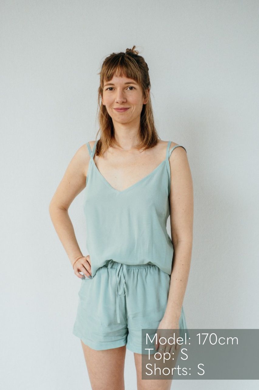 La femme fait face à l'appareil photo et pose en Kat haut et Kat pantalon en court