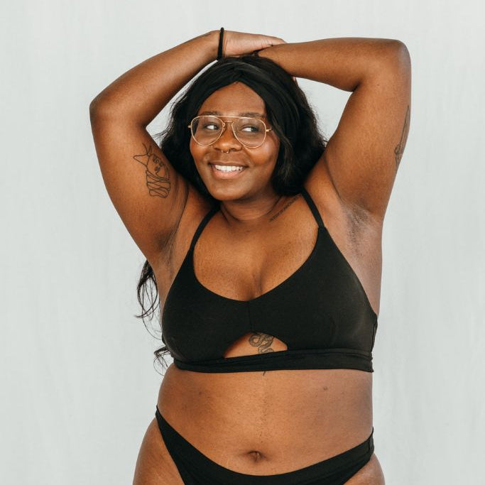 la femme porte le modèle Thea en noir en Tencel Lyocell, un matériau durable