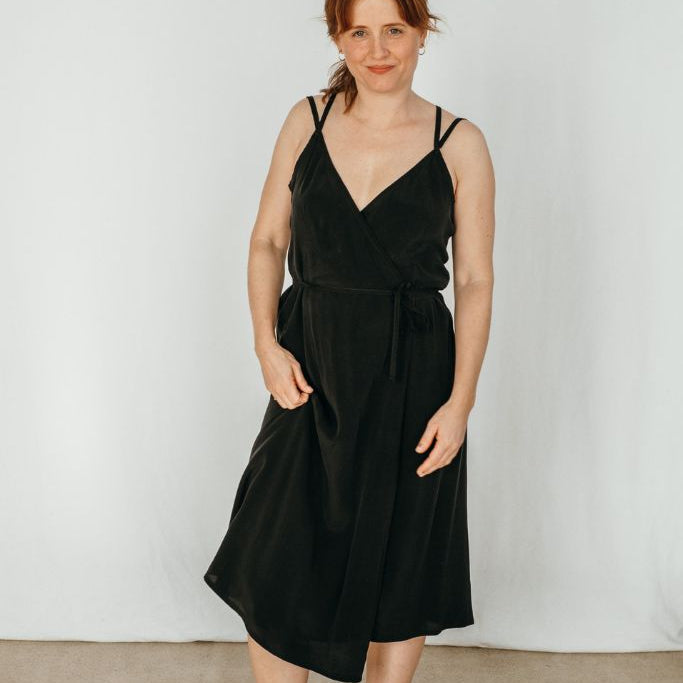 La femme pose dans une jolie robe Zia et regarde l'appareil photo