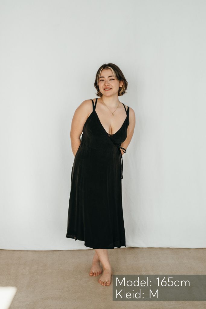La femme porte la robe-slip Zia en noir