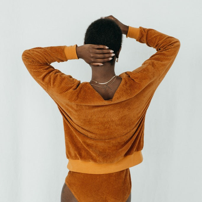 Model trägt Chloé Pullover in ockerfarbigem Cord, ihr Rücken ist der Kamera zugewandt