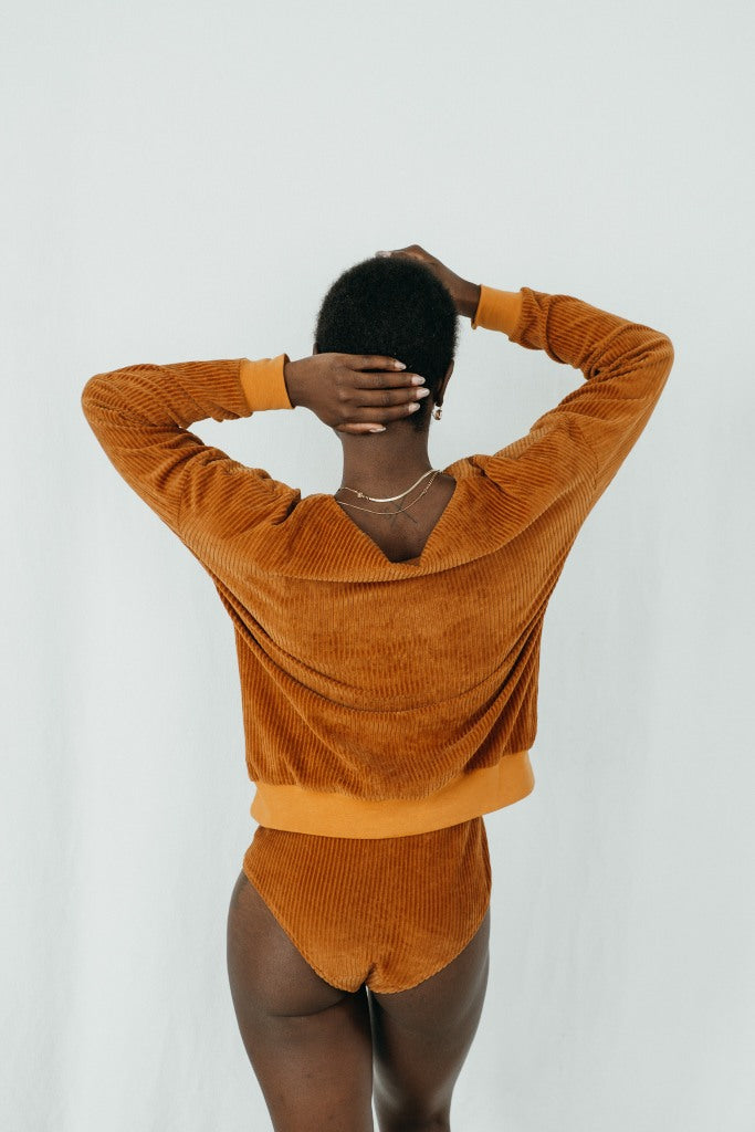 Model trägt Chloé Pullover in ockerfarbigem Cord, ihr Rücken ist der Kamera zugewandt