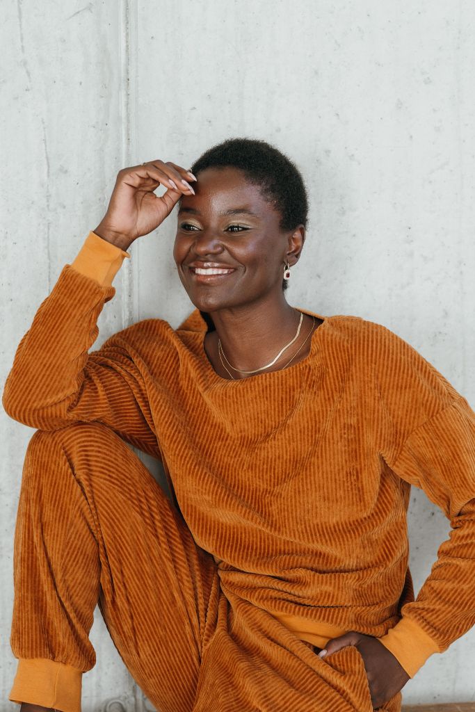 Portraitbild vom Model mit dem Chloé Pullover in Ocker. Sie blickt verträumt neben der Kamera vorbei.