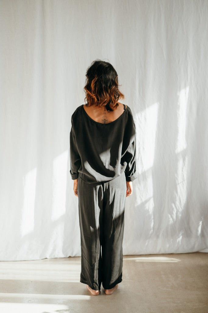 Frau vor weissem hintergrund trägt schwarzen Pyjama von thoughts of september.
