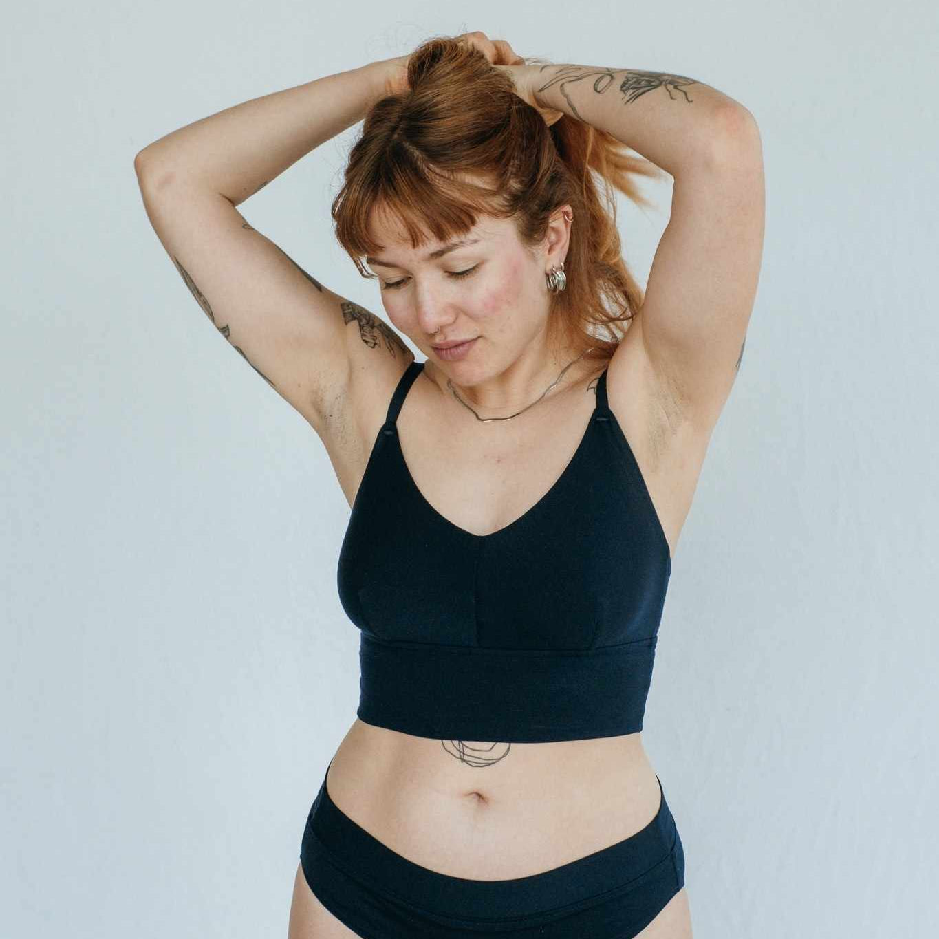 le modèle se tient les cheveux et porte de la belle lingerie en Tencel Lyocell fin