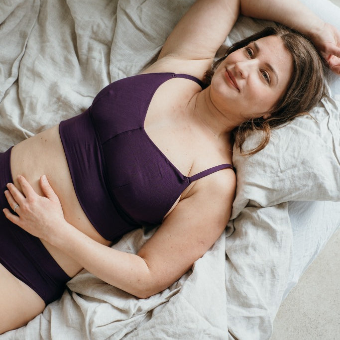 Moodbild von Emma in Ultraviolet. Model liegt auf dem Bett und sieht verträumt die Decke an.