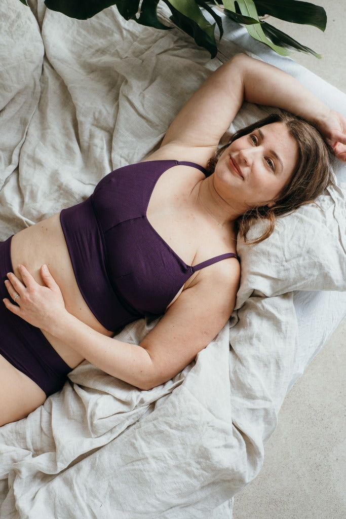 Moodbild von Emma in Ultraviolet. Model liegt auf dem Bett und sieht verträumt die Decke an.