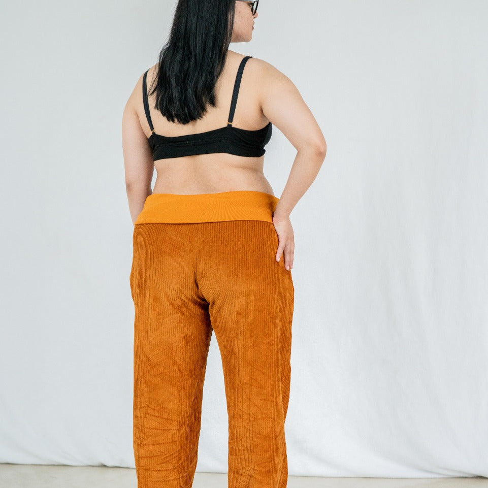 Model trägt Fiona Hose in ockerfarbigem Cord mit weichen Bündchen