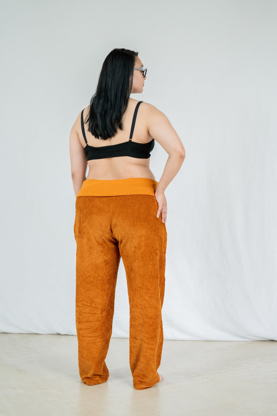 Model trägt Fiona Hose in ockerfarbigem Cord mit weichen Bündchen