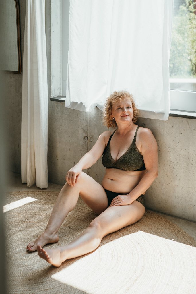 Model sitzt am Boden und trägt das Gisele Set. Den Rücken hat sie an der Wand angelehnt.