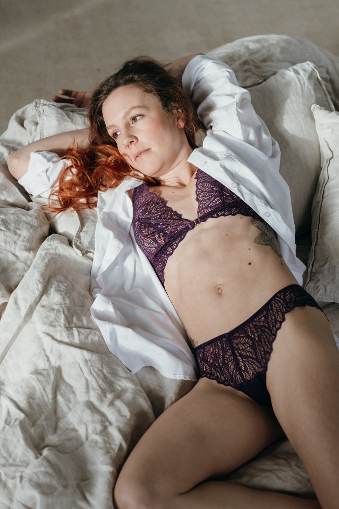 Moodbild von Joanne in Ultraviolet. Model liegt auf dem Bett und sieht zum Fenster hinaus.