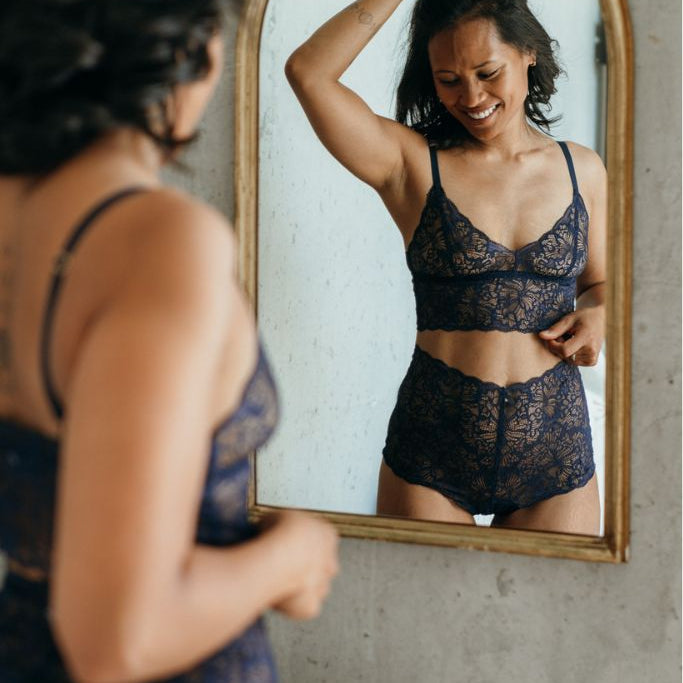 das Model bestaunt ihre Unterwäsche im Spiegel