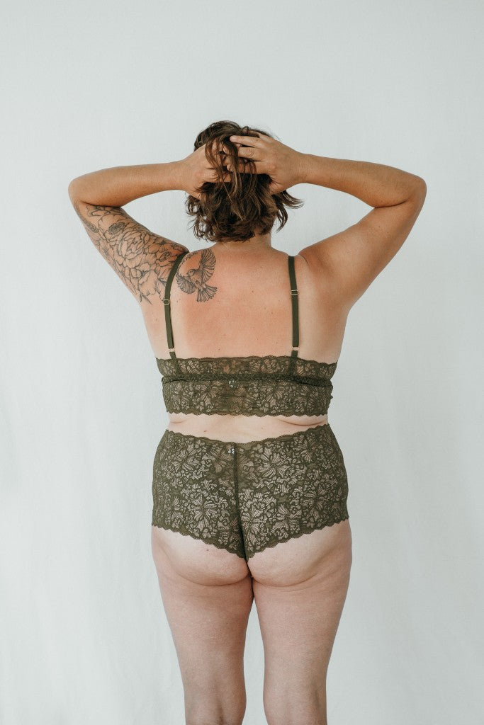 Model trägt das Joy Set in der Farbe Olive. Sie hat den Rücken der Kamera  zugewandt.