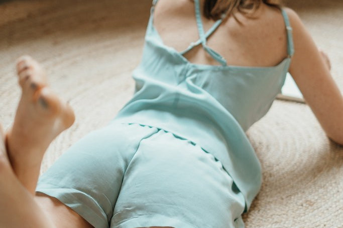 le mannequin allongé pose en short et avec le haut assorti.