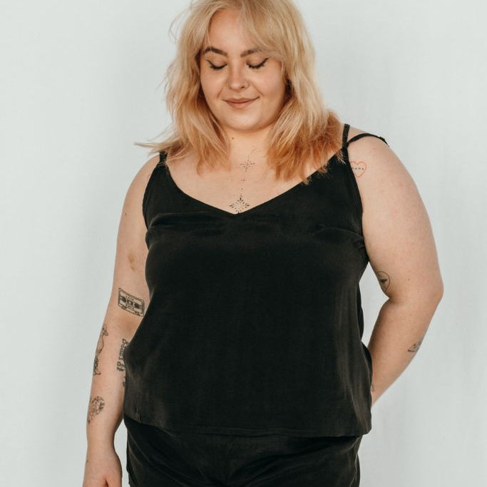 La femme porte le haut Kat et le pantalon court Kat de couleur noire.