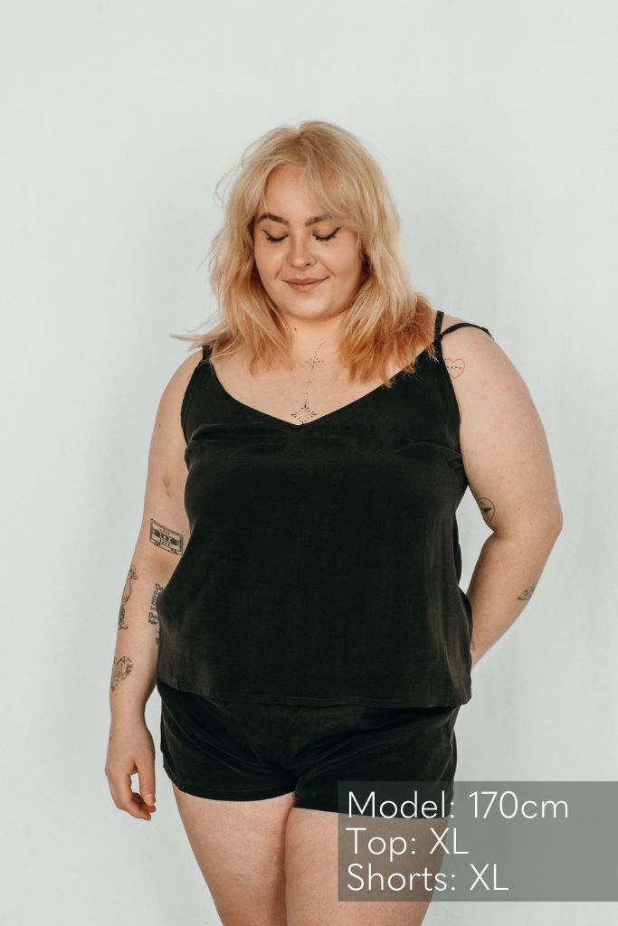 La femme porte le haut Kat et le pantalon court Kat de couleur noire.