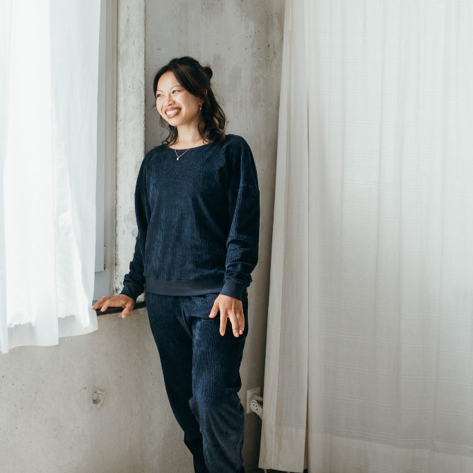 Model trägt Pyjama in Dunkelblauem Cord mit weichen Bündchen