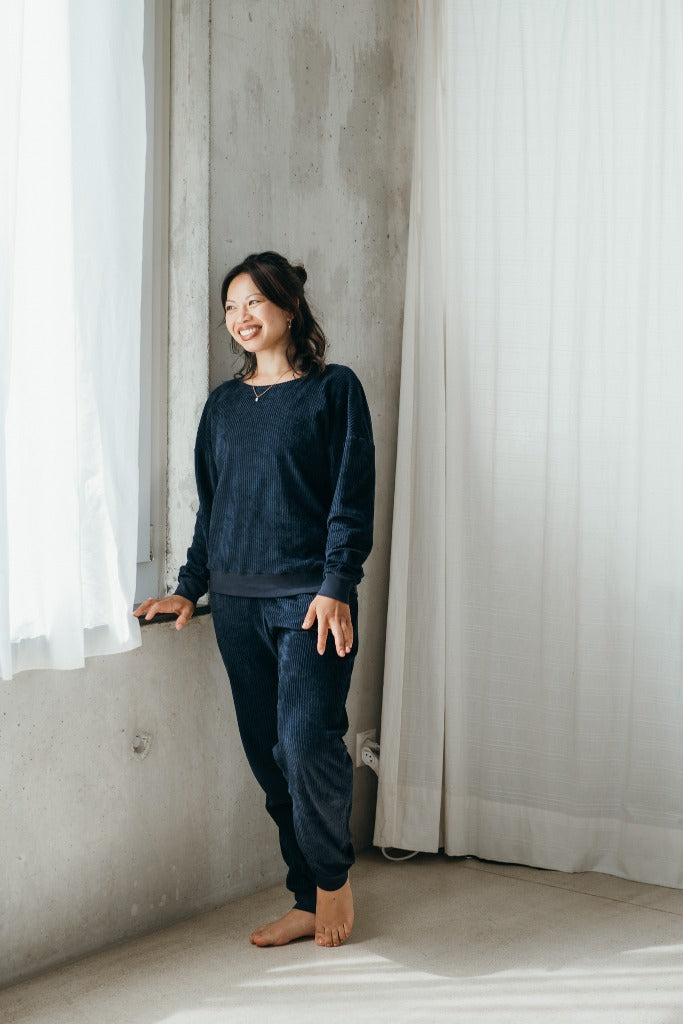 Model trägt Pyjama in Dunkelblauem Cord mit weichen Bündchen