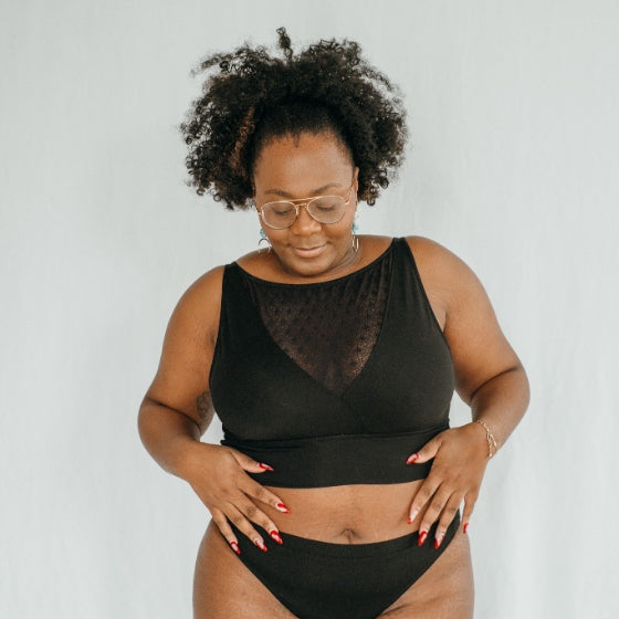 la femme porte le Leila Bralette  avec un décolleté profond en dentelle