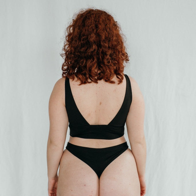 le modèle montre son derrière avec String et Bralette, qui sont cousus à la main en Suisse