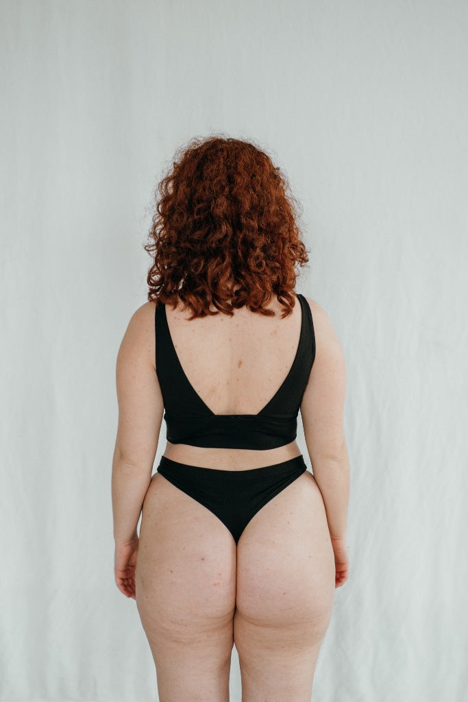 le modèle montre son derrière avec String et Bralette, qui sont cousus à la main en Suisse