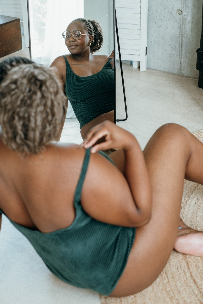 Detailaufnahme vom jadegrünen Ronja Body. Model sitzt vor dem Spiegel.