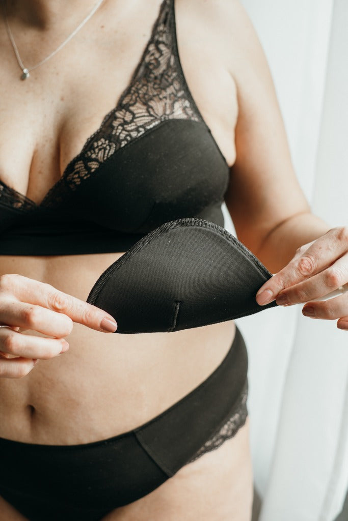 Foto zeigt eins unserer Models, die ein Pad vom Sophie Bralette in den Händen hält.