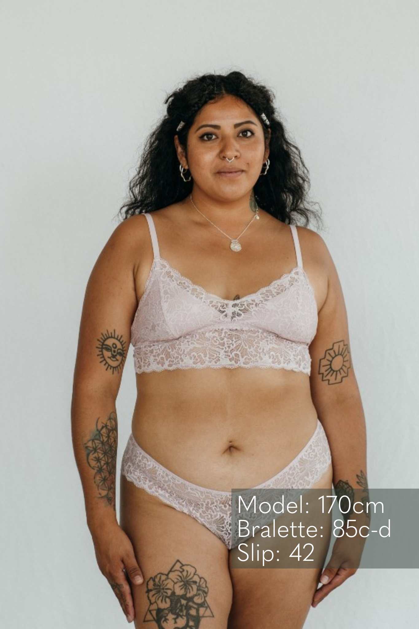 Die Frau tägt schöne Unterwäsche aus einer Unterhose und einem Bralette aus Spitze und unterlegtem Tencel