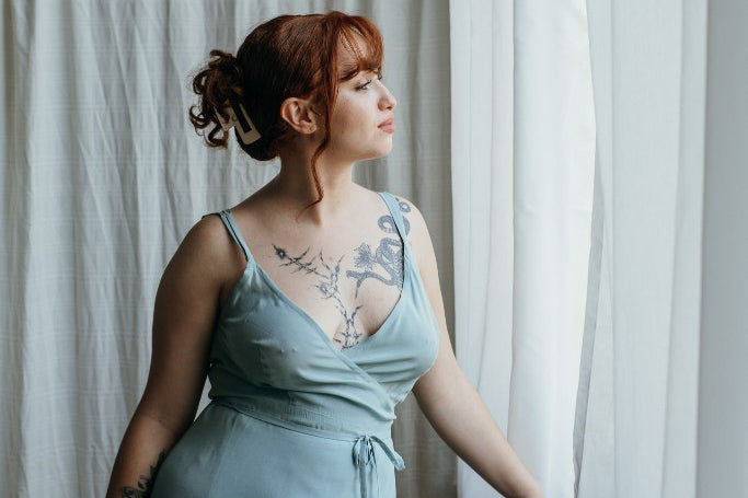 Model trägt das Zia Slipdress in der Farbe Summer Mint. Sie blickt zum Fenster hinaus.