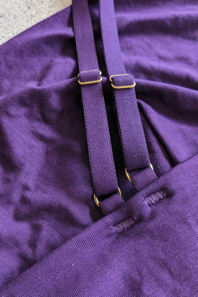 Back detail of double straps in purple with gold details.